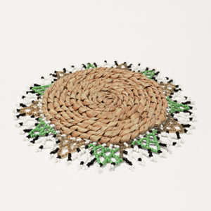 Fringed woven placemat with beads, featuring black, white, brown, and green bead accents. Elevate your table setting with this stylish accessory.